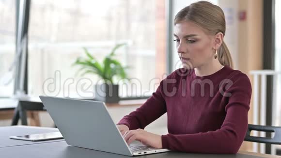 有手提电脑做拇指的年轻女子视频的预览图