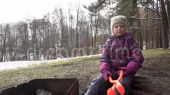 树林里的女孩拿着烤架和钳子打雪球视频的预览图