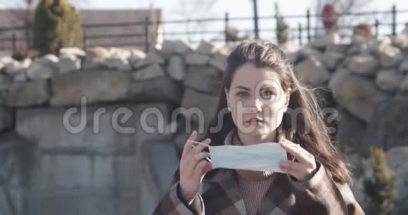 街上一个戴着防护面具的年轻女学生的肖像视频的预览图