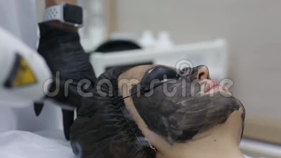 戴黑色面具的女人正在进行碳激光剥离视频的预览图