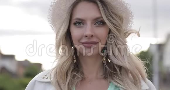 戴帽子的金发美女在镜头前微笑的头像视频的预览图
