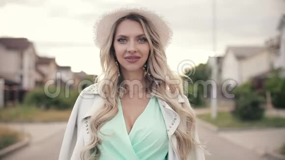 穿着薄荷长连衣裙白帽和白夹克的美女画像微笑视频的预览图