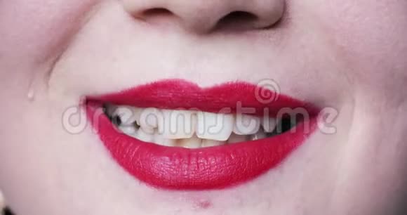 极端特写的女性嘴粉红色的口红微笑着露出洁白健康的美丽牙齿视频的预览图