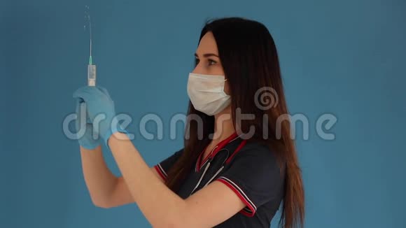 美丽的女医生穿着白色的医疗服戴着口罩戴着蓝色手套肩上戴着听筒被隔离在蓝色的肩膀上视频的预览图