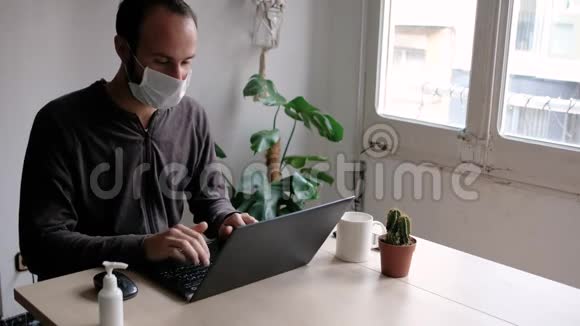 年轻的商人戴着医用面罩在家里工作由于目前的原因他担心经济和未来视频的预览图