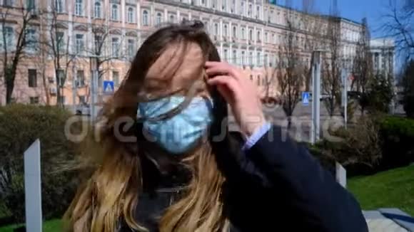 戴着蓝色面具的女孩走在有风的街道上视频的预览图