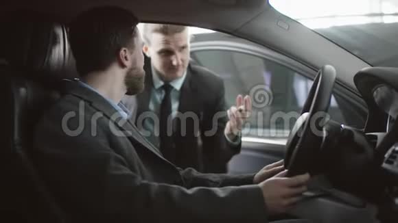 西装商人正和坐在车里的汽车买主谈话帅哥在和车商谈选择视频的预览图
