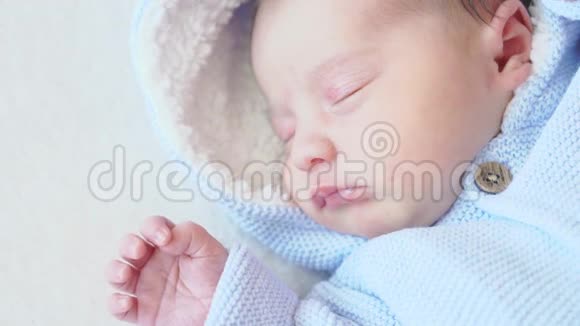 特写新生婴儿全生长俯视图穿着米色背景蓝色衣服的新生儿穿蓝色上衣的婴儿视频的预览图