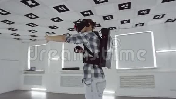 一个年轻人用虚拟现实耳机瞄准白色霓虹灯用360度镜头追踪他的手抖和瞄准视频的预览图
