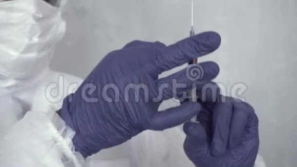一个穿着化学保护服的黑人手里拿着一个血注射器把它抖开然后视频的预览图