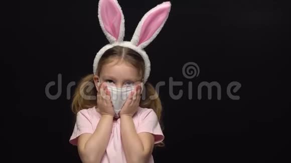 冠状病毒和空气污染的概念一个小女孩戴着保护面具和复活节兔子耳朵的服装视频的预览图