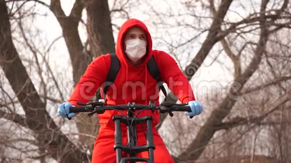 戴着医用口罩和手套的年轻人在乡下咳嗽穿红色西装保护自己免受疾病侵袭的成年男性视频的预览图