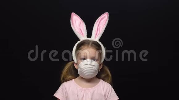 冠状病毒和空气污染的概念一个小女孩戴着保护面具和复活节兔子耳朵的服装视频的预览图