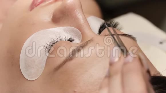 睫毛的延伸假睫毛睫毛延伸手术特写长睫毛的女人眼的肖像视频的预览图