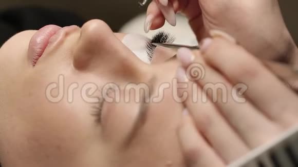 睫毛的延伸假睫毛睫毛延伸手术特写长睫毛的女人眼的肖像视频的预览图