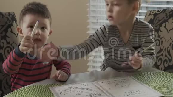 两个小弟弟坐在桌子旁在同一个颜色上画在一起哥哥教尿布视频的预览图