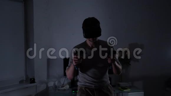 晚上或晚上戴虚拟现实头盔的年轻人使用控制器视频的预览图