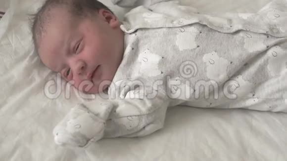 特写一个新生婴儿的脸在早期谁醒来眯着眼睛一个刚出生的婴儿视频的预览图