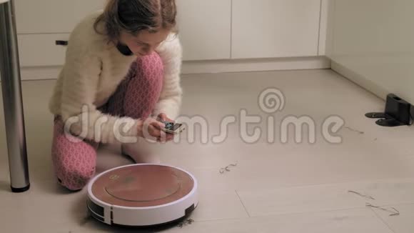 一个年轻的女人正在吸尘机器人视频的预览图
