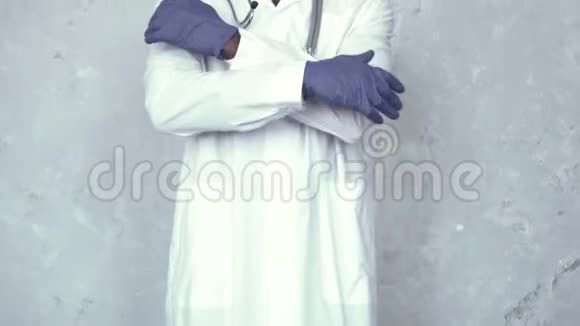 戴着防护眼镜戴着医用口罩脖子上戴着听诊器的非洲男医生穿过他的蓝色视频的预览图