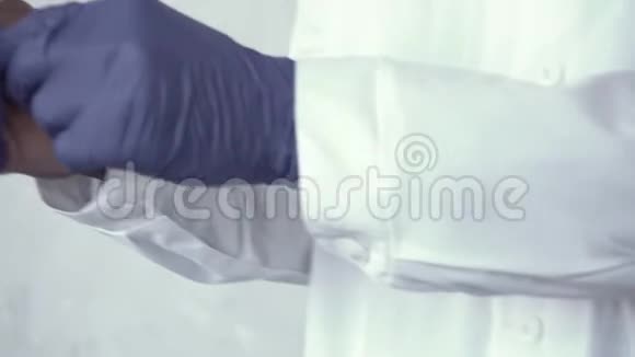 非洲男医生双手合拢双手戴着蓝色手套站在水泥墙上冠状病毒流行病视频的预览图