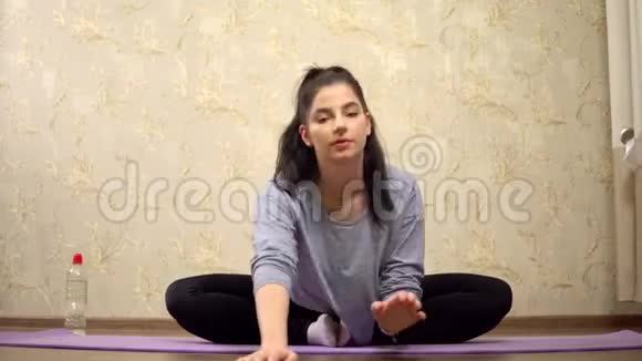 年轻女子开始做伸展运动练习瑜伽视频的预览图
