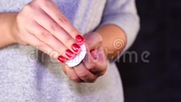 女人去掉指甲油女士用白色棉垫去除红色指甲油视频的预览图