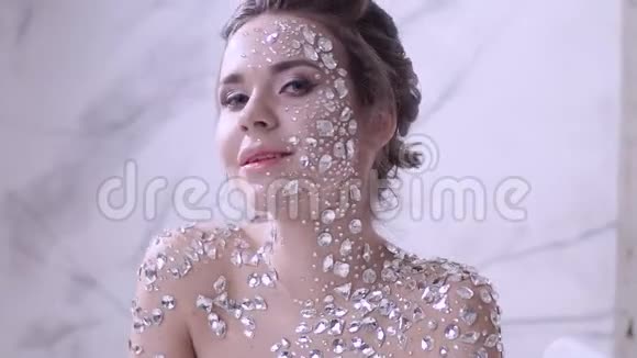 不寻常的化妆和面部艺术与闪闪发光的莱茵石在皮肤上视频的预览图