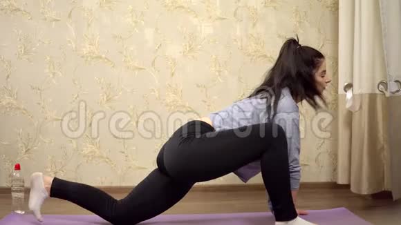 女孩的腿在垫子上做运动健身训练家庭伸展运动视频的预览图