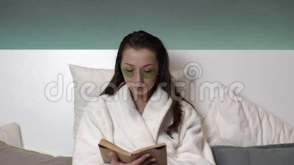 穿着浴袍眼睛上打哈欠睡着的疲惫性感女人视频的预览图