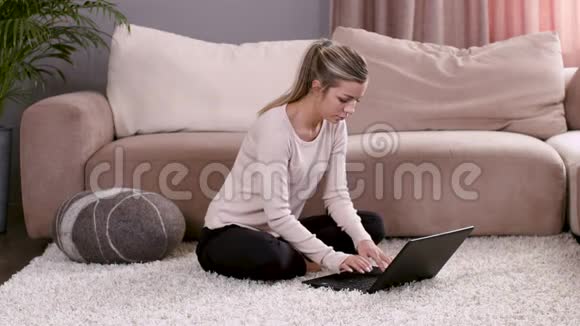 一个白人女孩坐在家里手提电脑和一只棕色的狗跑过来亲吻视频的预览图