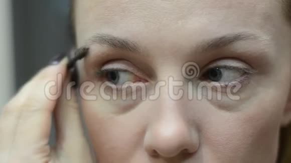 年轻女子在镜子旁涂睫毛膏视频的预览图