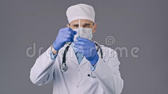 穿着制服和口罩的实验室技术员拿起注射器倒一些液体视频的预览图