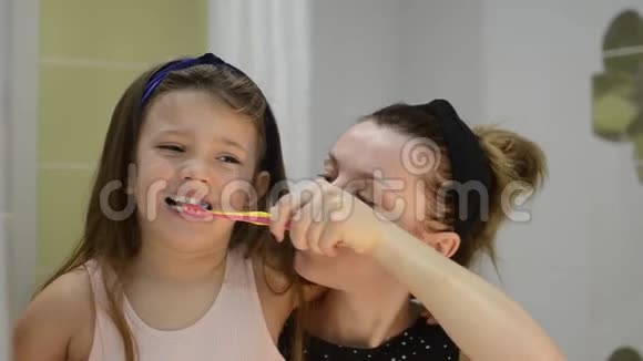 年轻的母亲给她的女儿刷牙视频的预览图