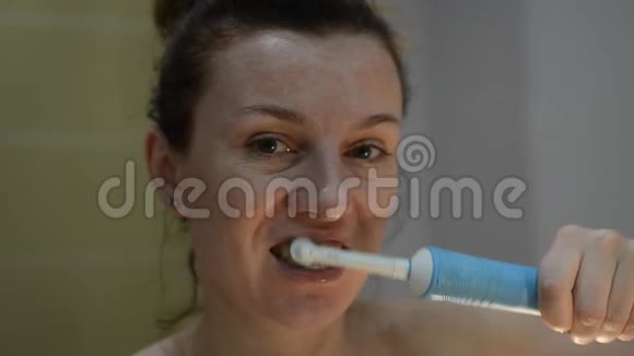 年轻女子用电动牙刷刷牙视频的预览图