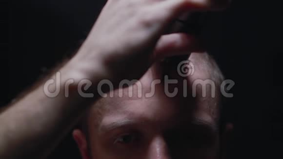 年轻人正在镜头前黑暗的房间里用剪刀割伤自己视频的预览图