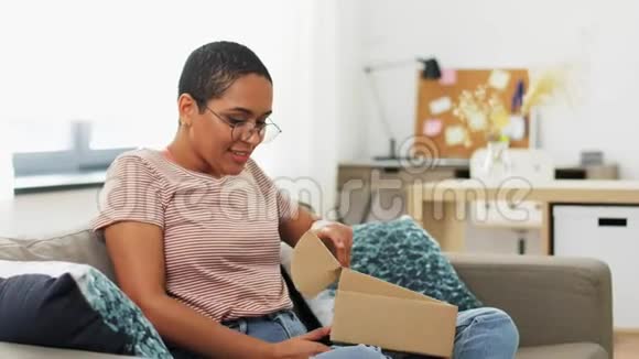 非洲裔美国妇女在家打开包裹盒视频的预览图