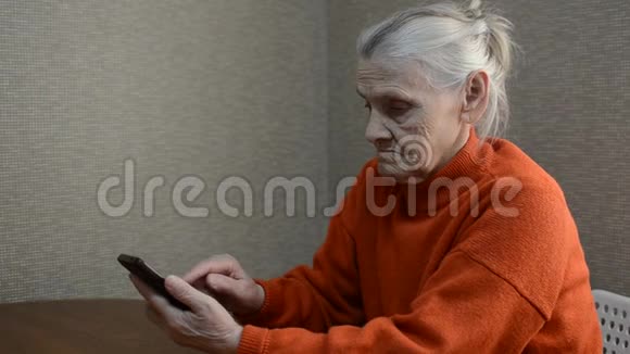 一位老年妇女在智能手机上留言视频的预览图