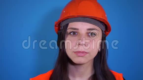 穿工作服的女建筑工人在蓝色背景上脸上戴医用口罩视频的预览图