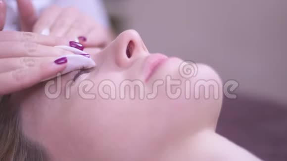 一个专业的美容师在一个高加索女人的脸上做美容视频的预览图