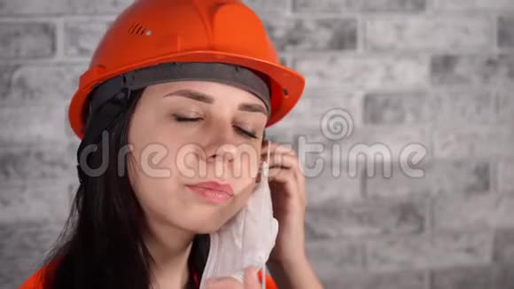 穿工作服的女建筑工人在灰砖墙背景上戴医用口罩视频的预览图