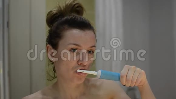年轻女子用电动牙刷刷牙视频的预览图