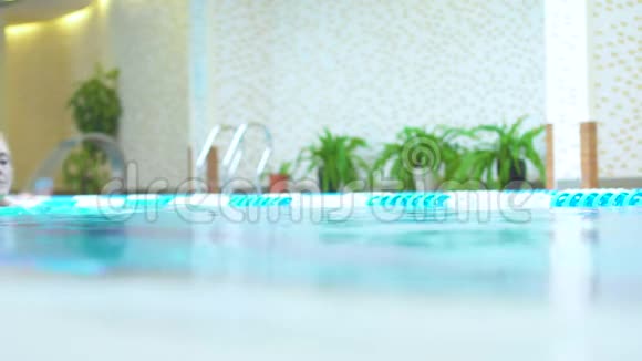 高加索女人在酒店游泳池游泳健康的生活方式视频的预览图