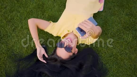 快乐的笑女躺在草地上自拍4K视频的预览图