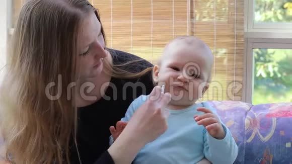妈妈在婴儿护理中给宝宝喷一剂感冒药视频的预览图