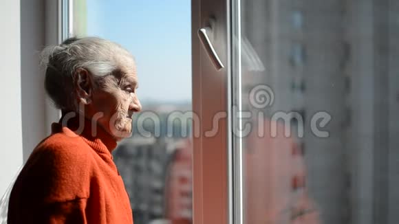 阳光明媚的一天一位老妇人打开窗户视频的预览图