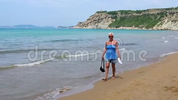 希腊夏季中年女性在海滩上散步视频的预览图