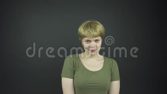 穿绿色t恤的漂亮女士动了动摸了摸脸视频的预览图