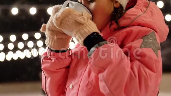 冬天在溜冰场喝热茶的女孩视频的预览图