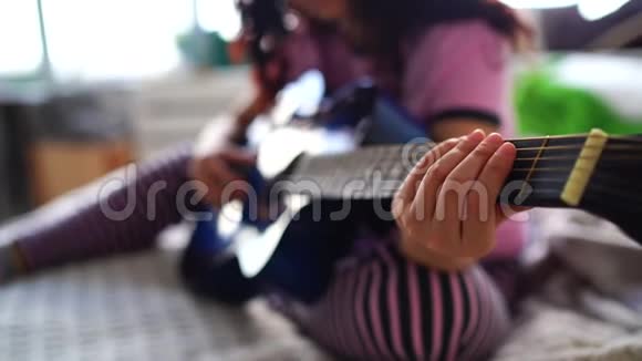年轻女子在卧室弹吉他特写女性手弹吉他弦视频的预览图